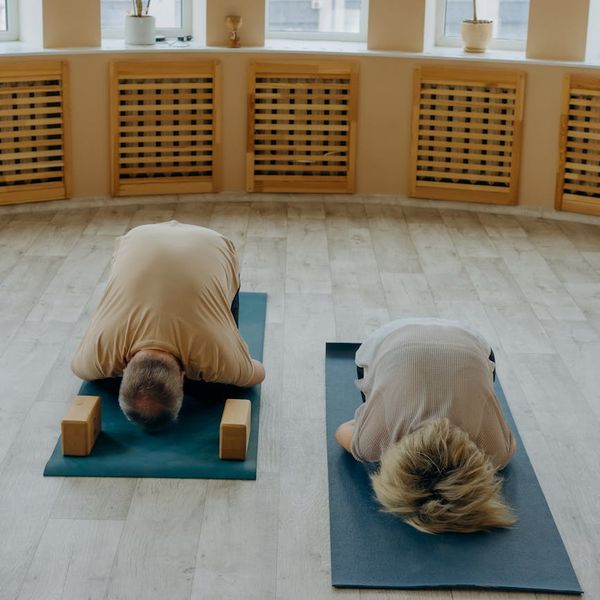 Man in deep concentration during a flexibility exercise in a minimalist setting.